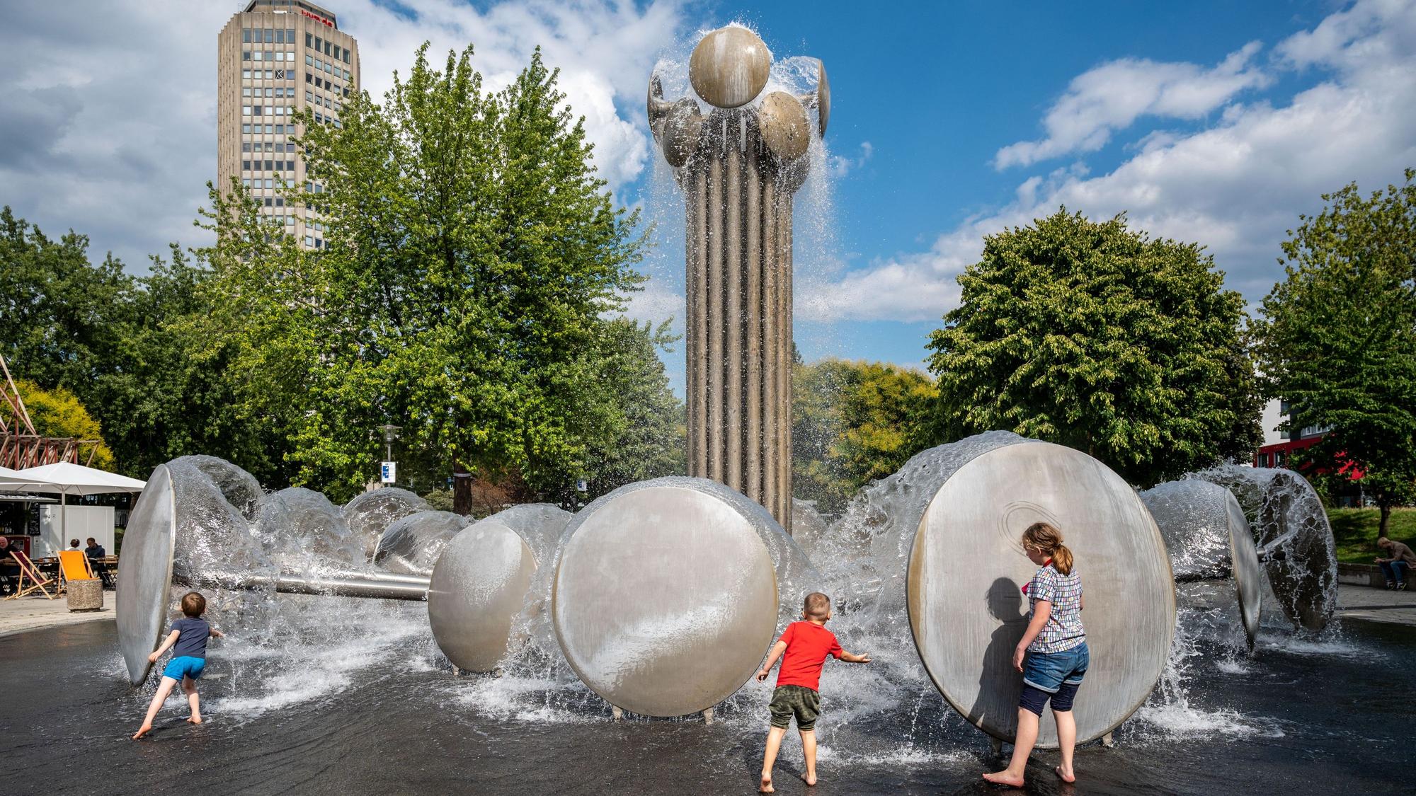 Kinder spielen am Brunnen auf dem Ebertplatz.