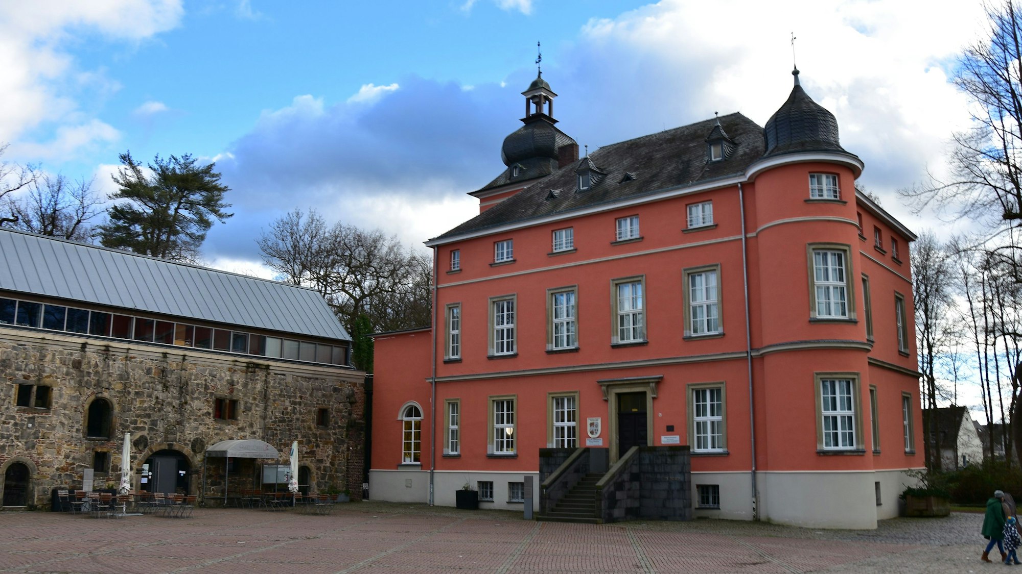 Ein terrakottafarben gestrichenes Schloss mit zwei Zwiebeltüren