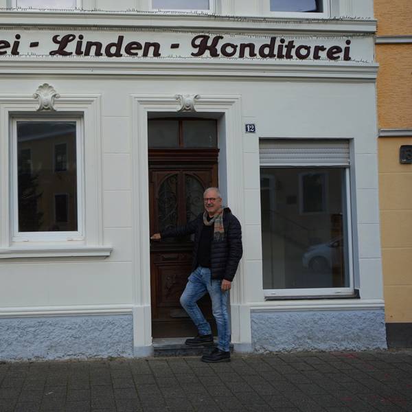 Ein Mann steht vor einem Gebäude.
