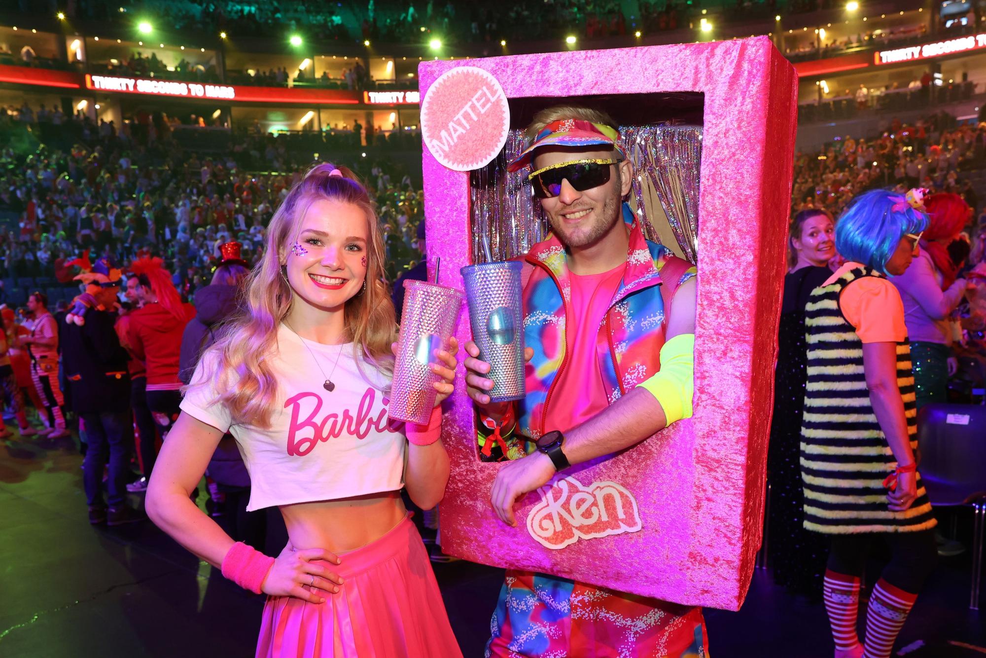 Ein junger Mann und eine junge Frau in rosa Barbie-Kostümen.