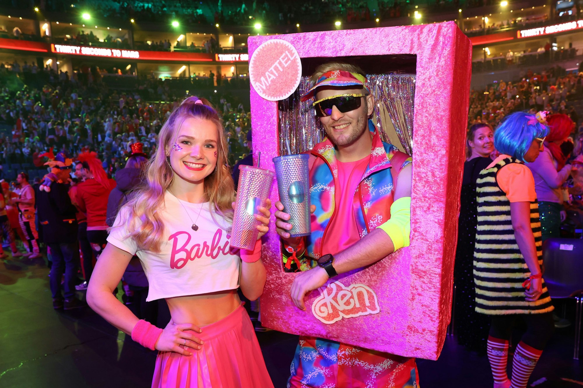 Ein junger Mann und eine junge Frau in rosa Barbie-Kostümen.