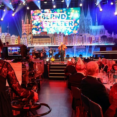 Eine Kamerafrau filmt aus der Saalmitte in Richtung Bühne, auf der Bernd Stelter steht.