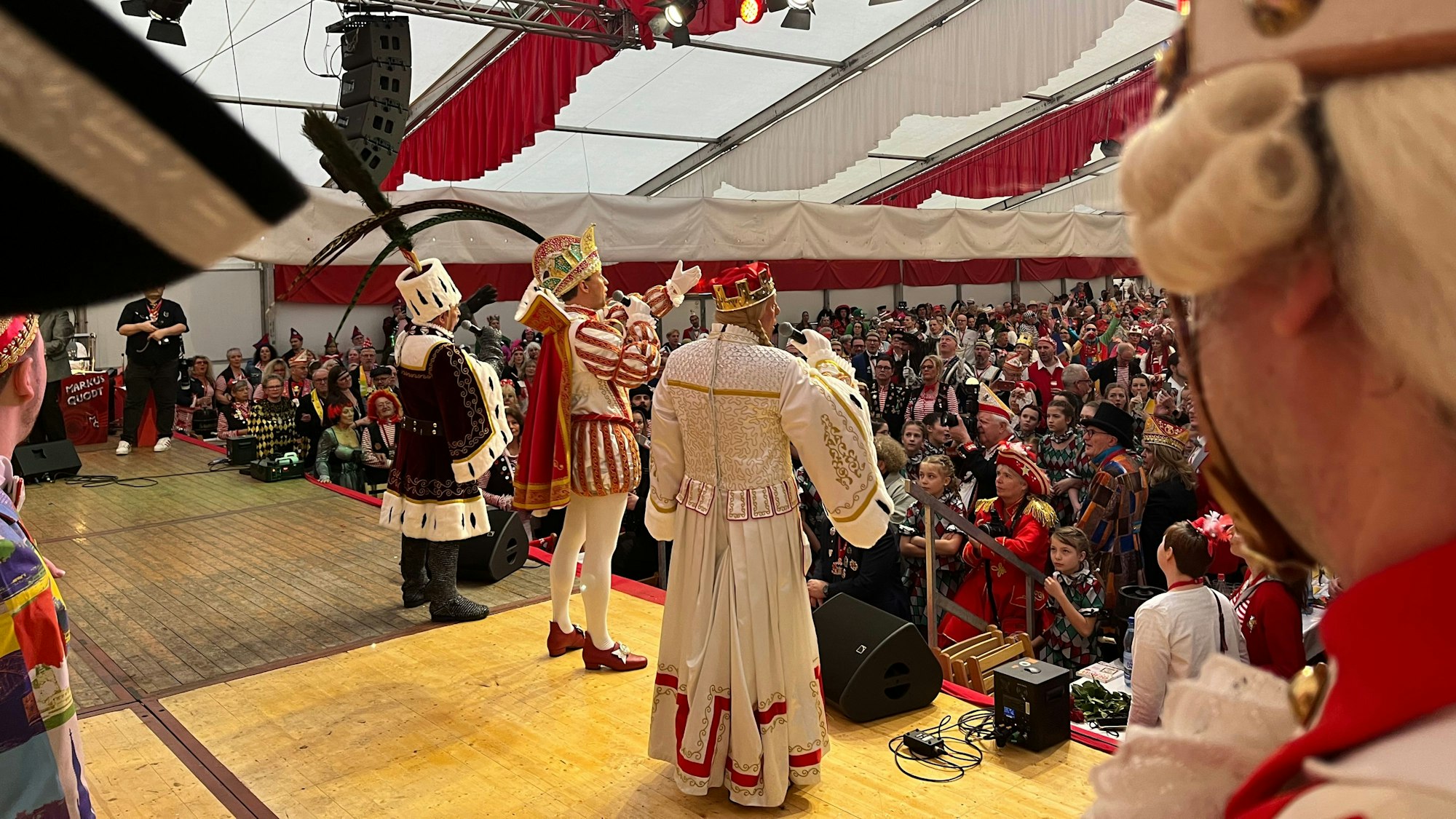 Das Kölner Dreigestirn ist von hinten auf der Bühne des Festzelts zu sehen.