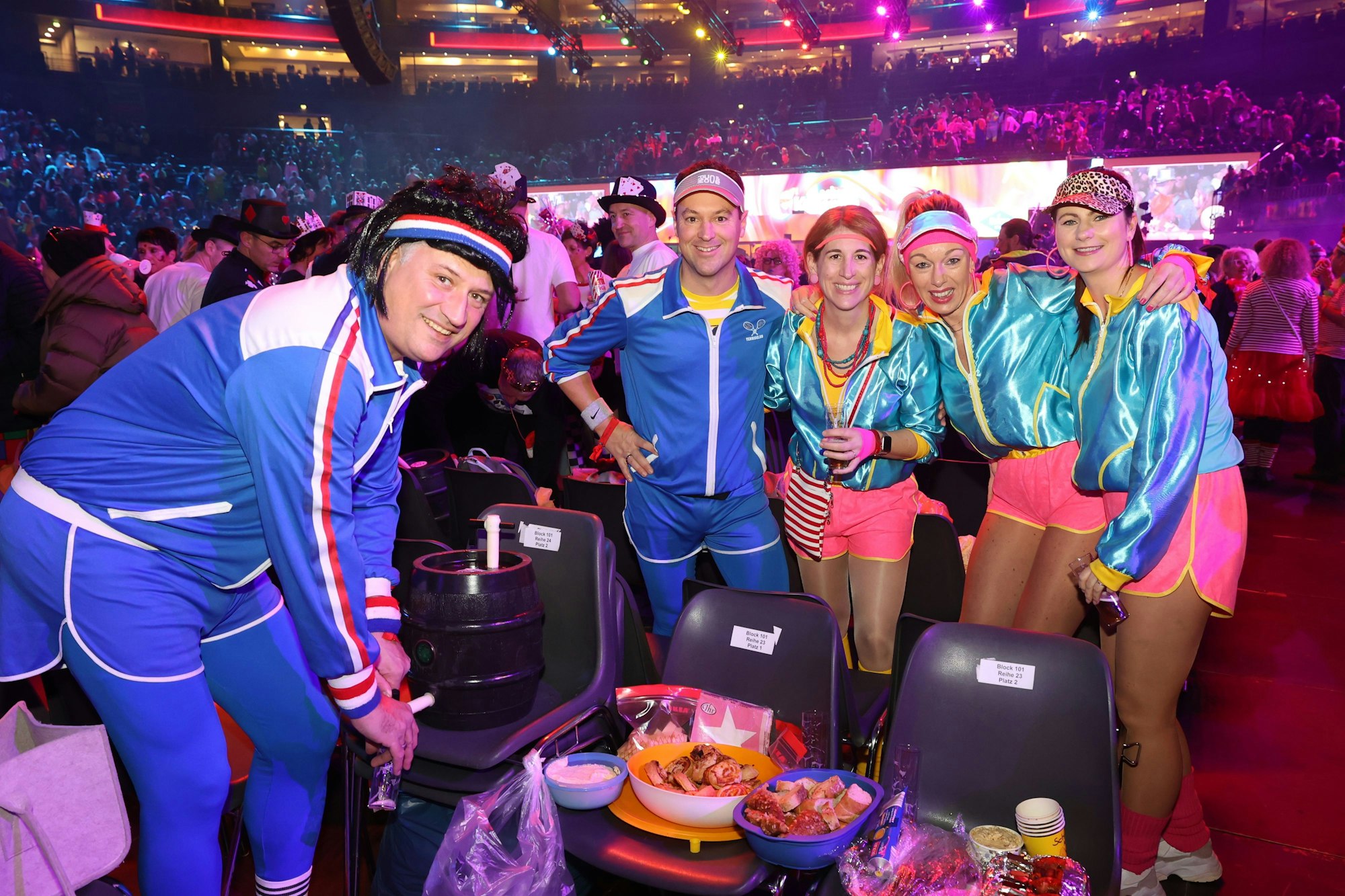 Zwei Männer und drei Frauen in blauen Sportanzügen posieren zusammen.