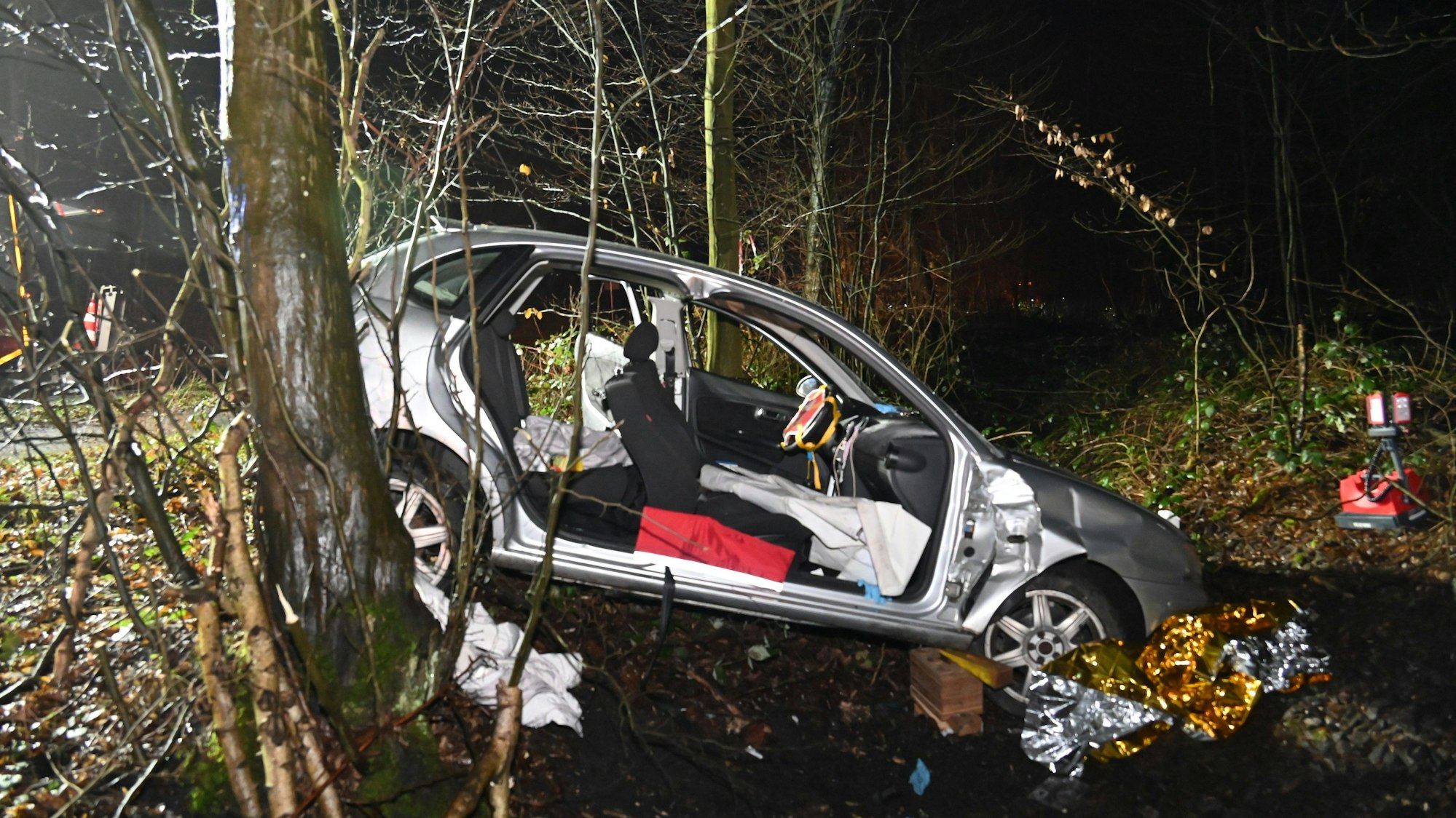 Ein Wagen liegt in einem Straßengraben. Die Türen wurden aus dem Fahrzeug herausgeschnitten.