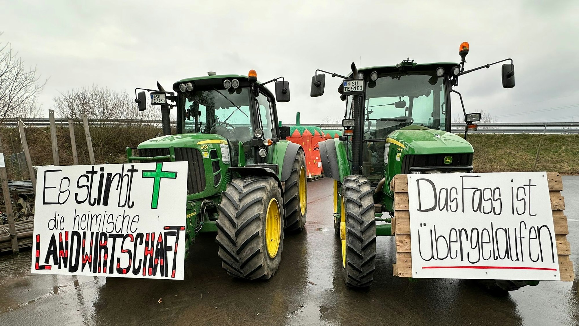 Die Bauern im Rhein-Sieg-Kreis sind für die Protestaktionen vorbereitet. An den Traktoren sind Protestplakate angebracht. Auf ihnen steht:„Es stirbt die heimische Landwirtschaft“ und „Das Fass ist übergelaufen“.