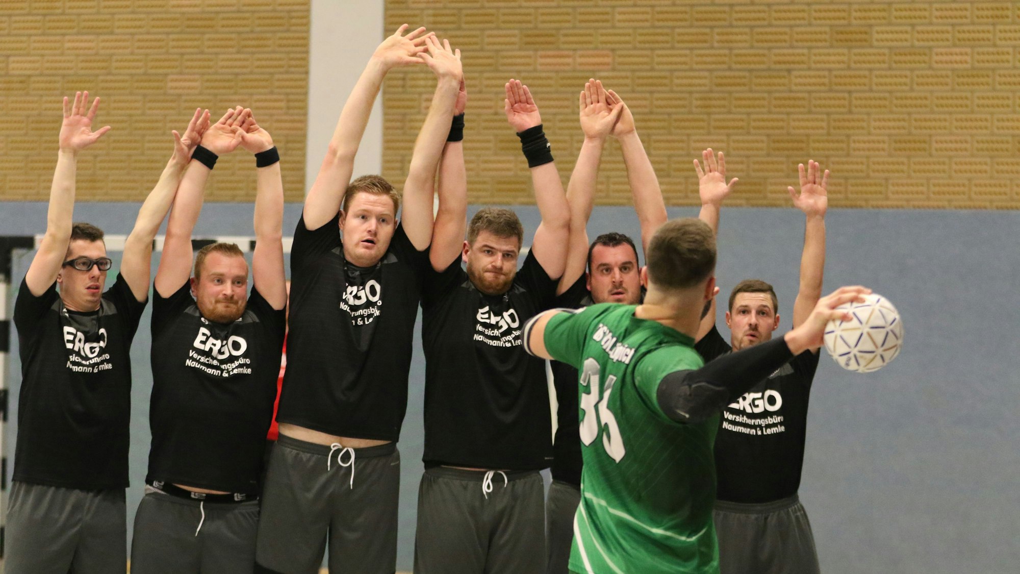 Der Kaller SC bildet eine Mauer, die Spieler reißen beim Freiwurf von Daniel Schüller die Arme hoch.