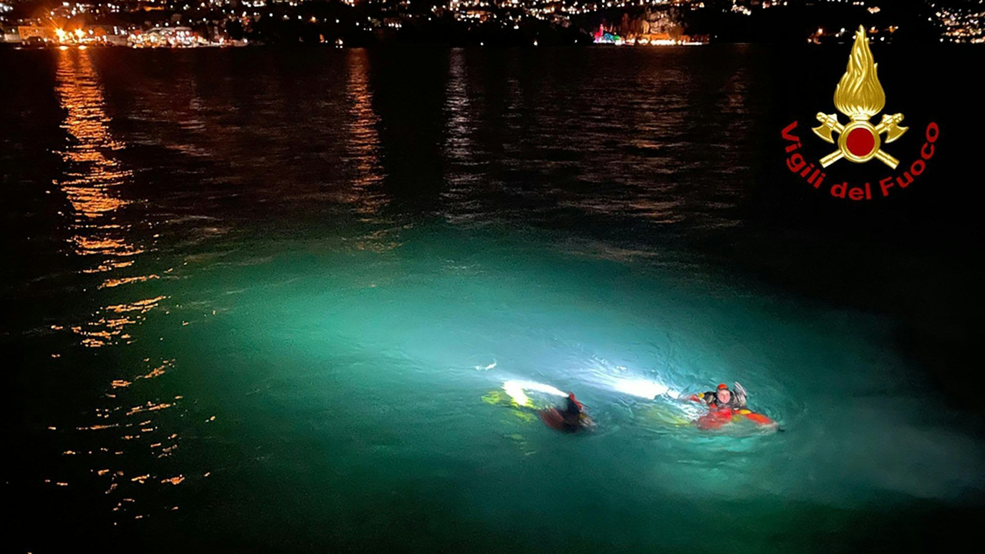 HANDOUT - 07.01.2024, Italien, Como: Rettungskräfte schwimmen im Comer See, in den zwei Menschen mit ihrem Auto gestürzt sind. Die 45 Jahre alte Frau und der 38-jährige Mann konnten am Sonntag nur noch tot aus dem Wasser gezogen werden, wie die Polizei mitteilte. Foto: -/Vigili del Fuoco/dpa - ACHTUNG: Nur zur redaktionellen Verwendung im Zusammenhang mit der aktuellen Berichterstattung und nur mit vollständiger Nennung des vorstehenden Credits +++ dpa-Bildfunk +++