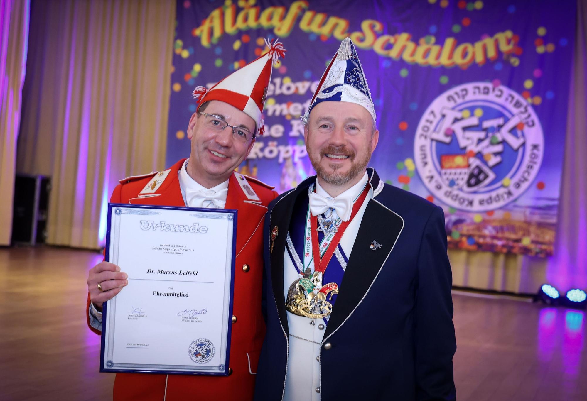 Ehrenmitglied Marcus Leifeld (links) mit Urkunde und Aaron Knappstein vor einem Plakat der Kippa Köpp.