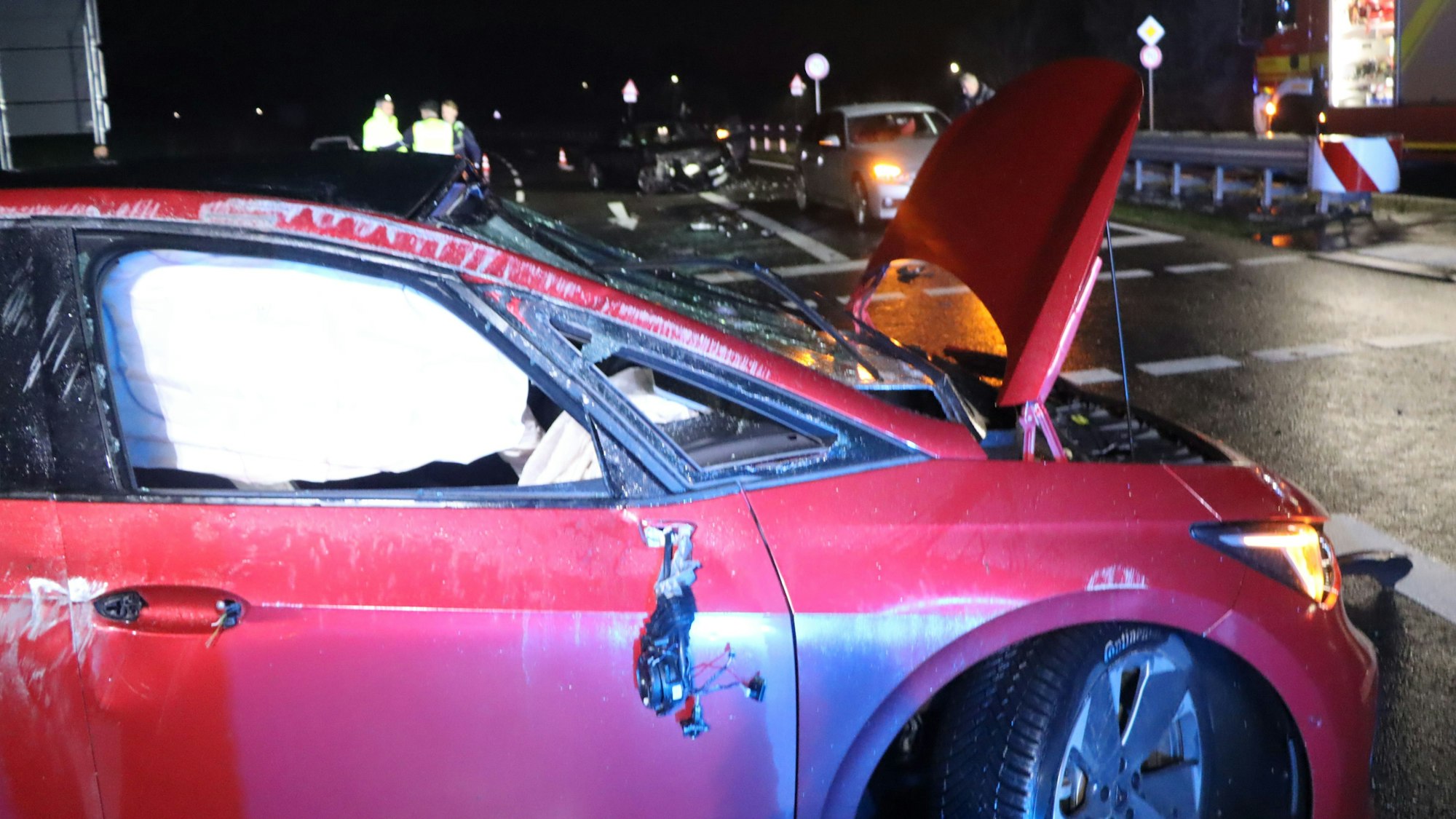 Feuerwehrleute fegen nach einem Unfall Glassplitter von einer Fahrbahn.