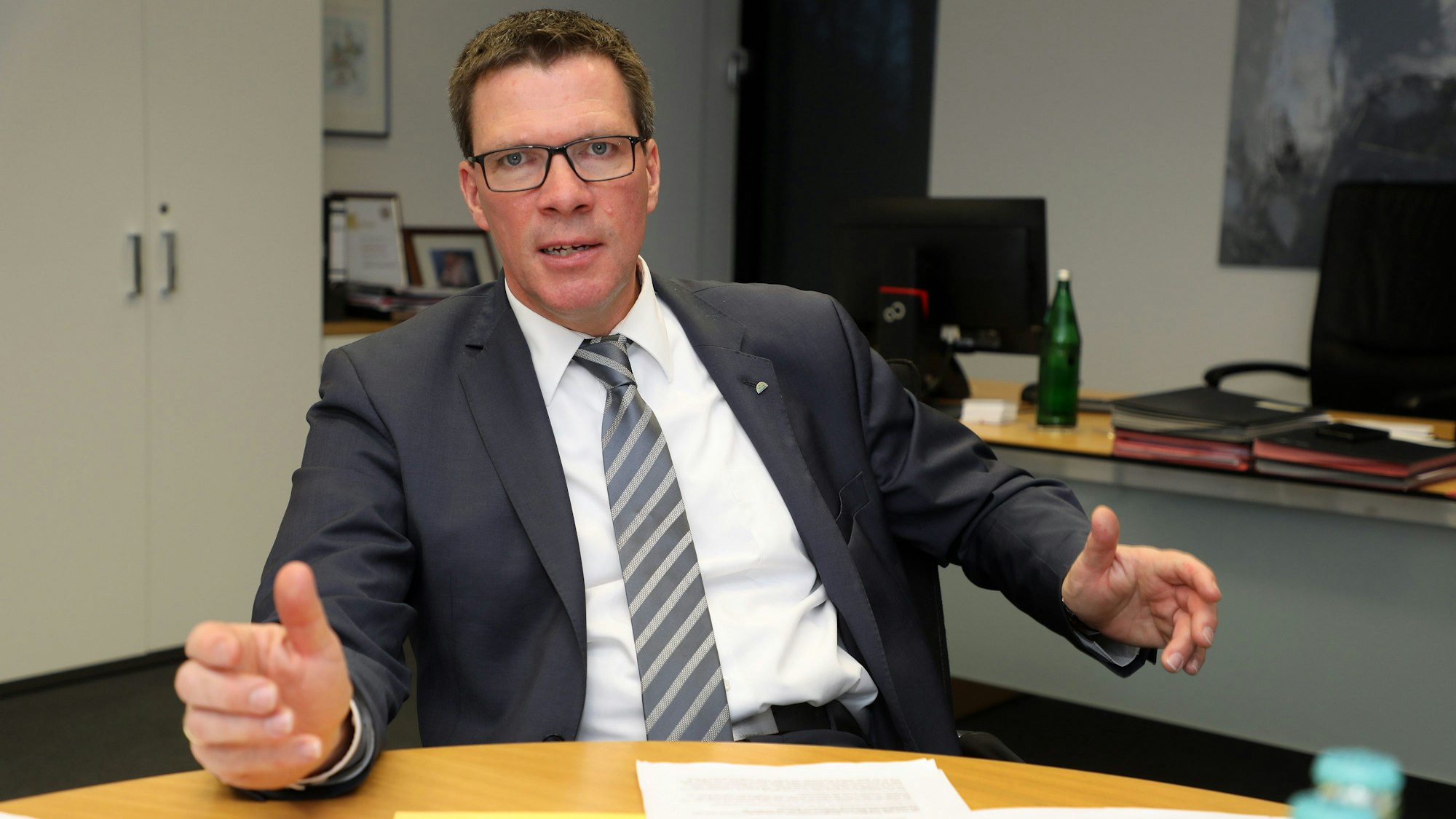 Rhein-Bergs Landrat Stephan Santelmann (CDU) sitzt an einem Tisch in seinem Büro im Kreishaus Am Rübezahlwald.