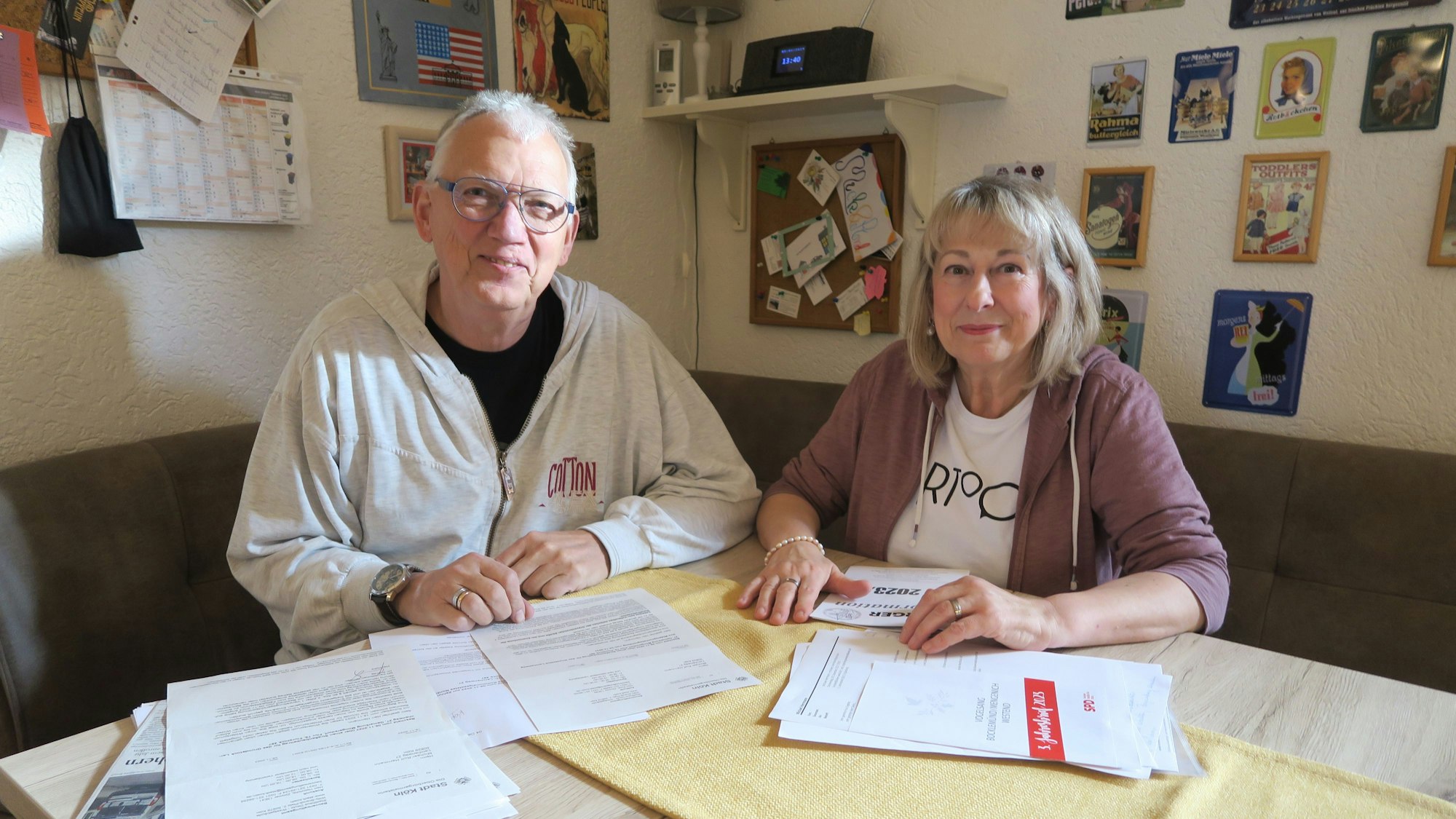 Ein Mann und eine Frau sitzen an einem Tisch, auf dem Papiere ausgebreitet sind.