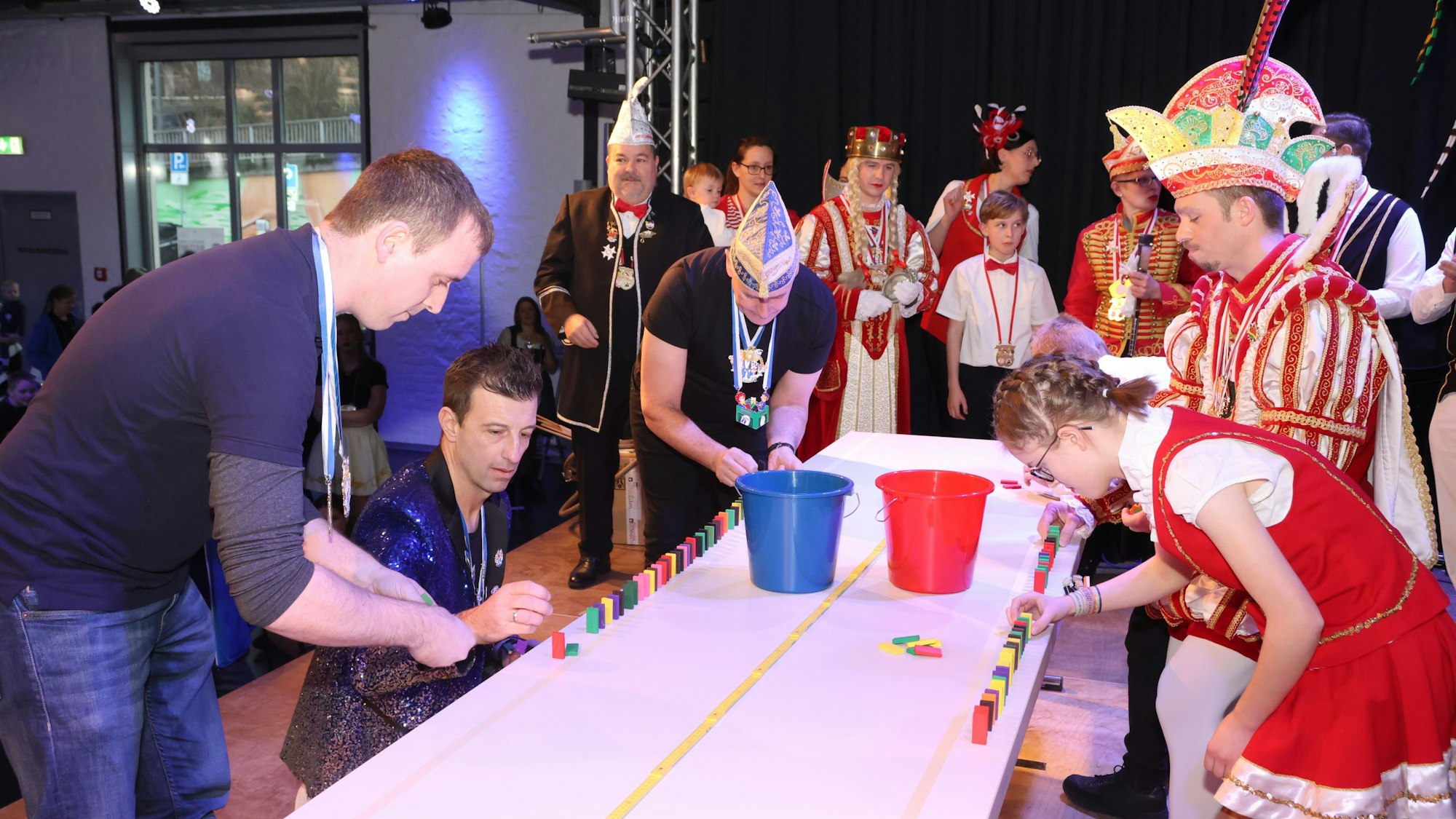 Das Foto zeigt zwei Teams, die Dominoreihen errichten