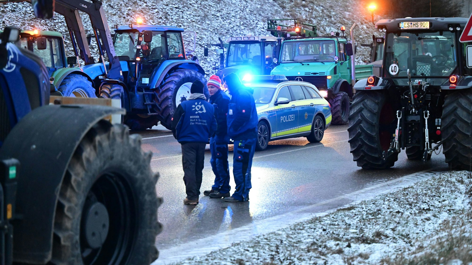 Mit Traktoren blockieren Landwirte die Zufahrt zur Autobahn A8.