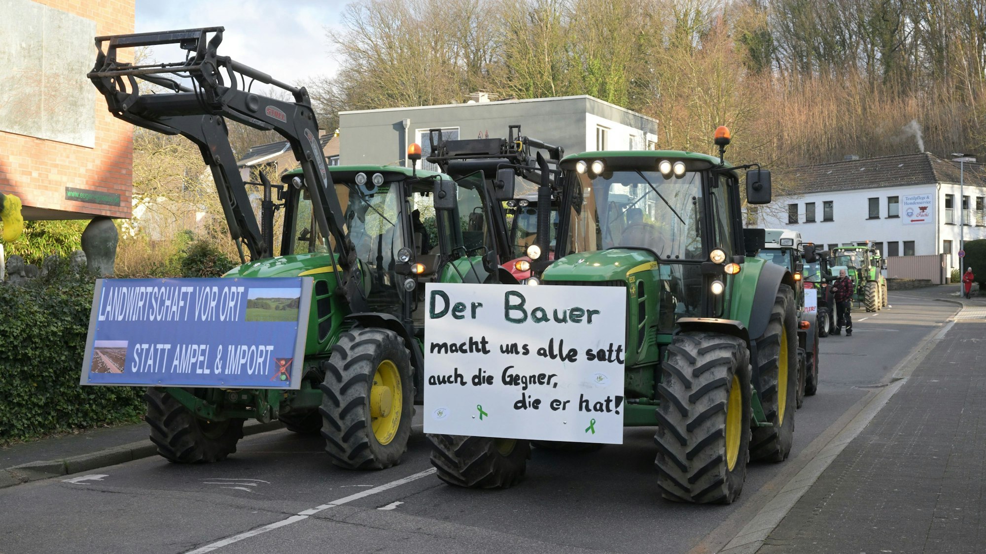 Traktoren fahren in zwei Reihen die Reuterstraße in Bergisch Gladbach herunter.