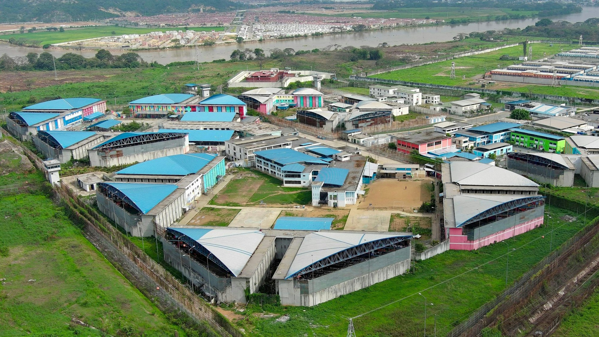 TOPSHOT - Aerial view of the Regional 8 prison in Guayaquil, Ecuador, taken on January 7, 2024, as the National Police and Armed Forces carry out a joint security operation. This operation, which included an intervention at the Guayas 4 Male Social Rehabilitation Centre, is the first such measure taken by President Daniel Noboa. (Photo by Marcos PIN / AFP)