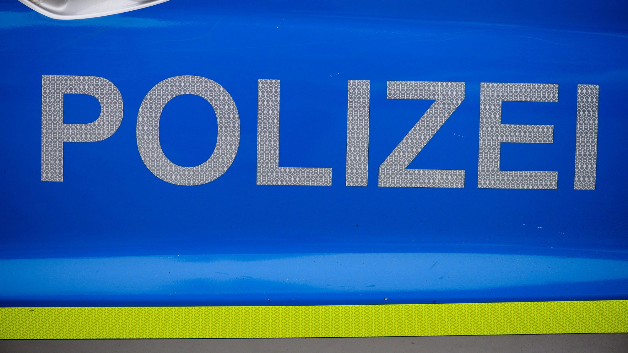 „Polizei“ ist auf einer Tür eines Polizeiautos zu lesen.