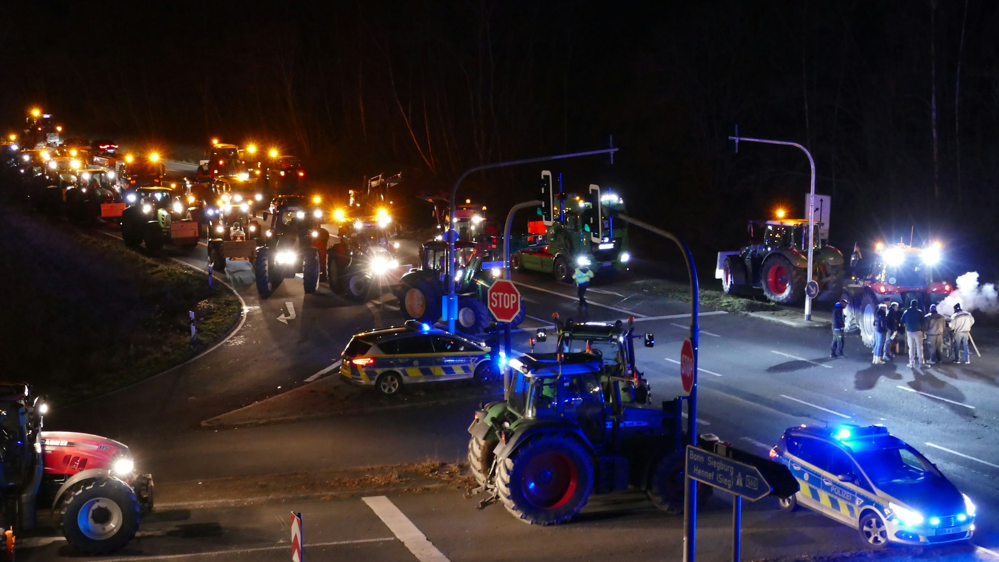 Zahlreiche Traktoren stehen auf einer Straße.