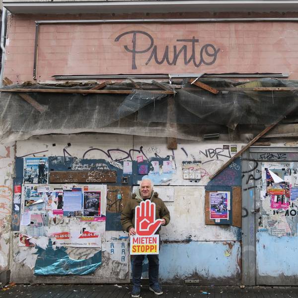 Ein Mann steht vor einem verrammelten Haus.