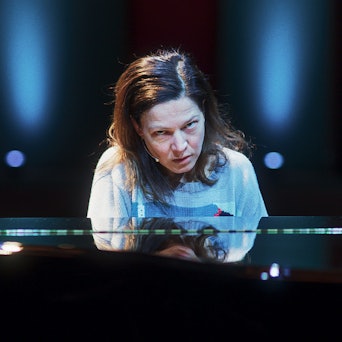 Die Szene zeigt Jenny von Loeben vor einem Flügel. Sie schaut geradezu wahnhaft in Richtung der Kamera.