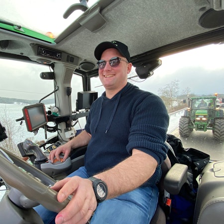 Landwirt Sebastian Bützler sitzt in seinem Trecker. Hinter ihm folgt ein weiterer Trecker.