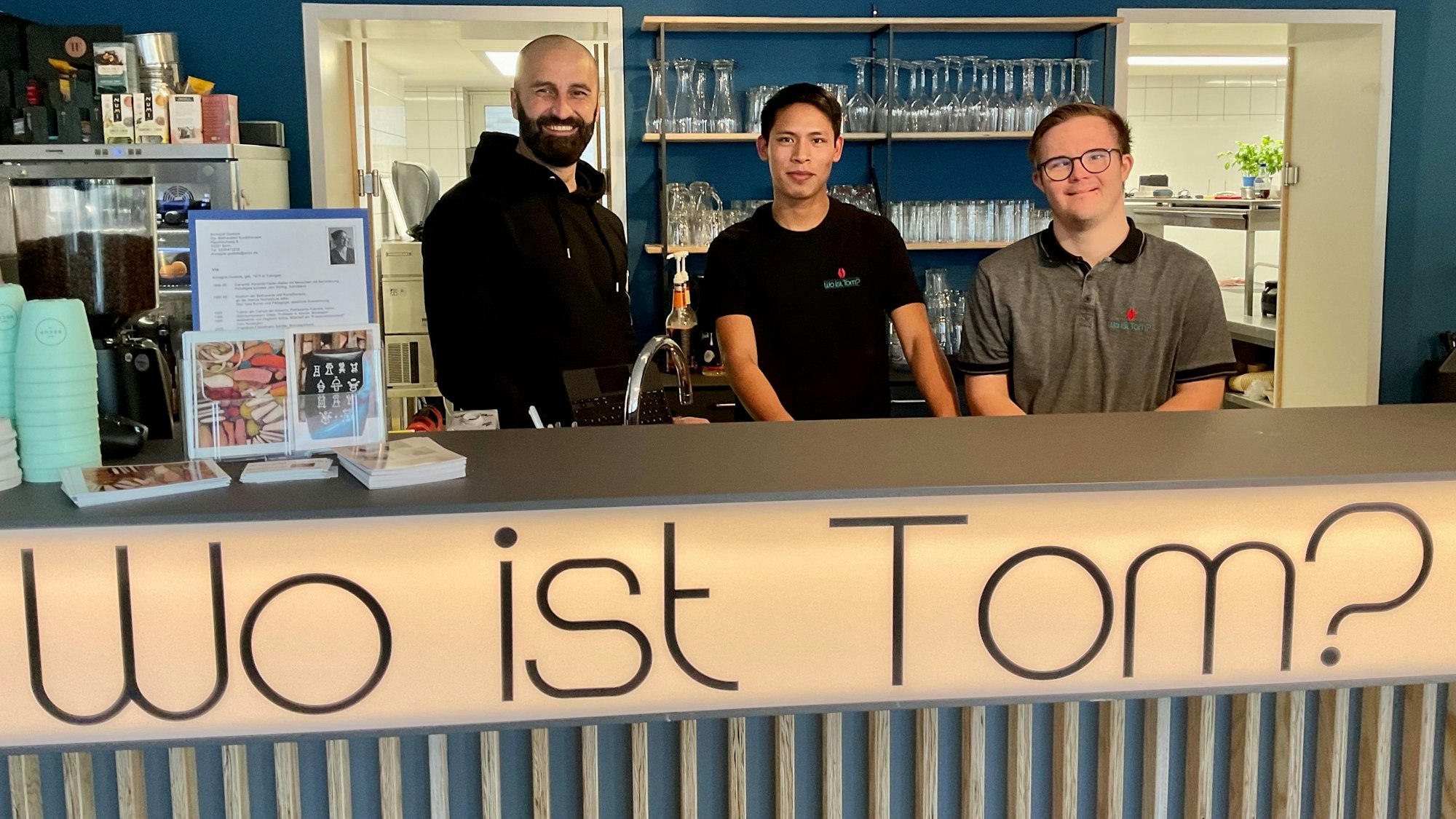Drei Männer hinter einer Café-Theke