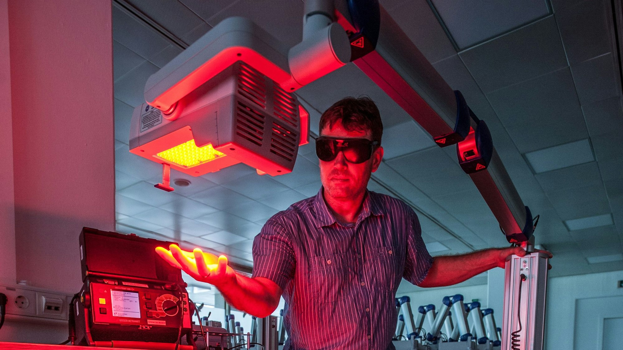 Ein Mitarbeiter testet die Rotlichtlampe bei Biofrontera