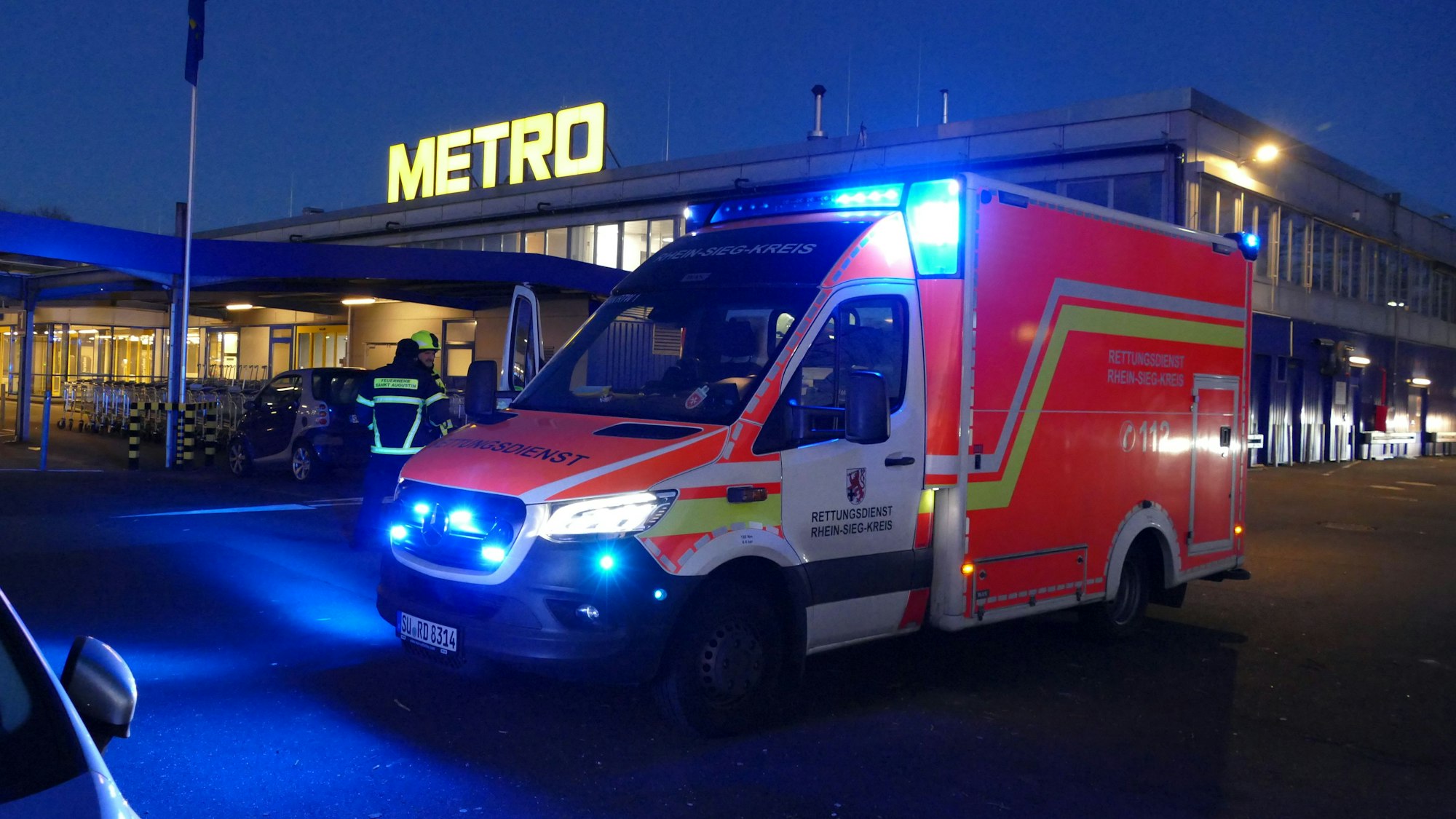 Ein Rettungswagen steht vor einem Großmarkt.
