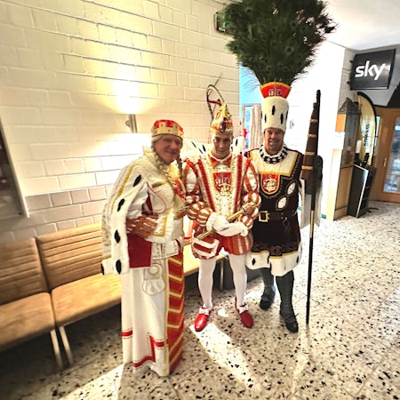 Das Dreigestirn steht im Eingangsbereich einer Halle.
