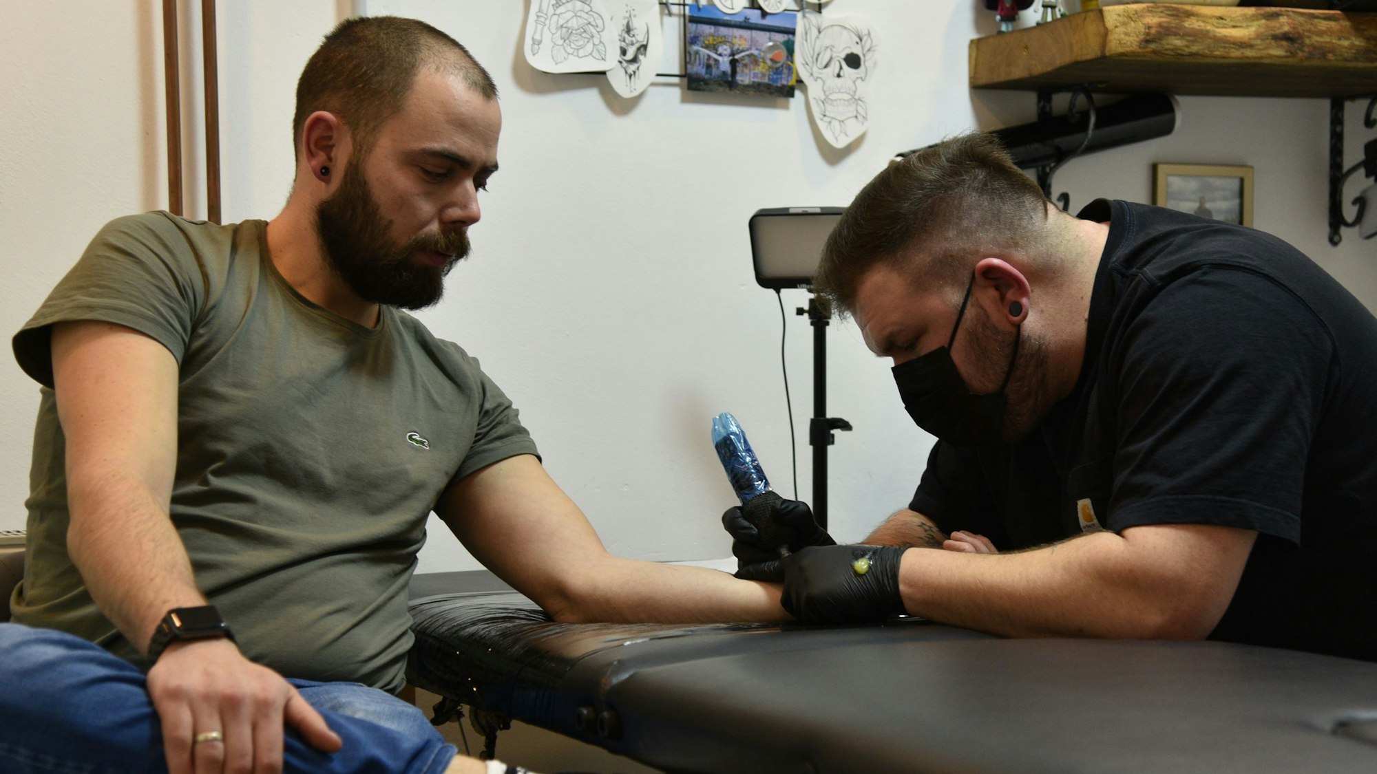 Mann bekommt Tattoo gestochen.