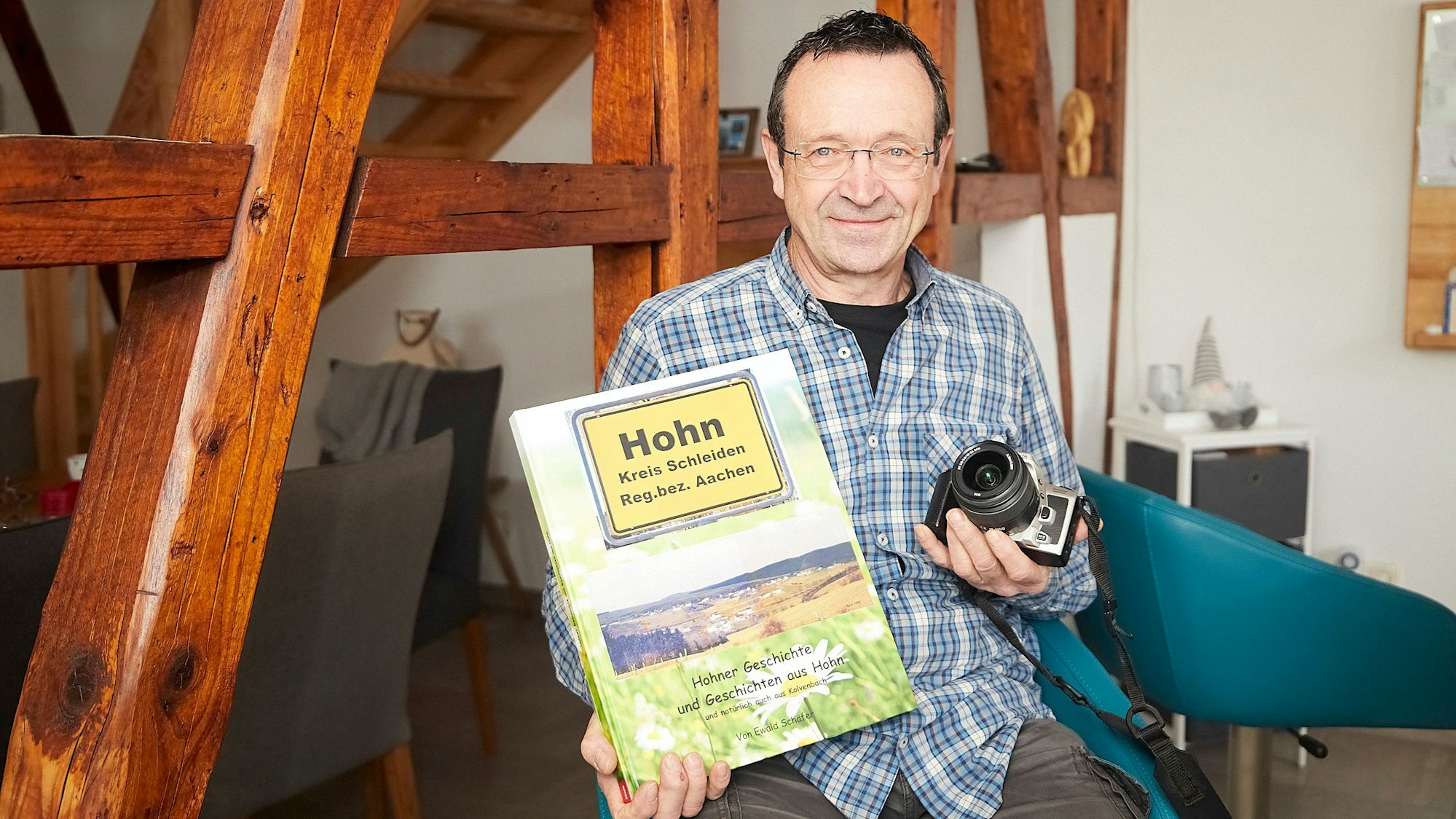 Ewald Schäfer mit dem Fotobuch und einer seiner alten, analogen Minolta-Kameras