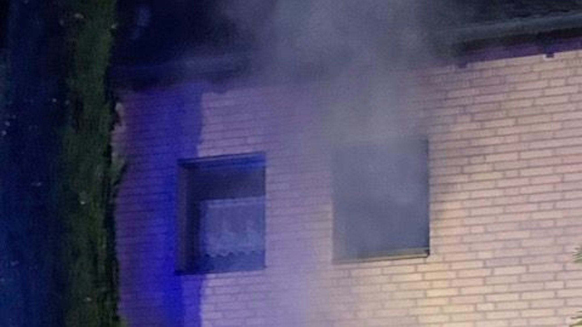 Zwei Fenster. Aus einem dringt schwarzer Rauch.