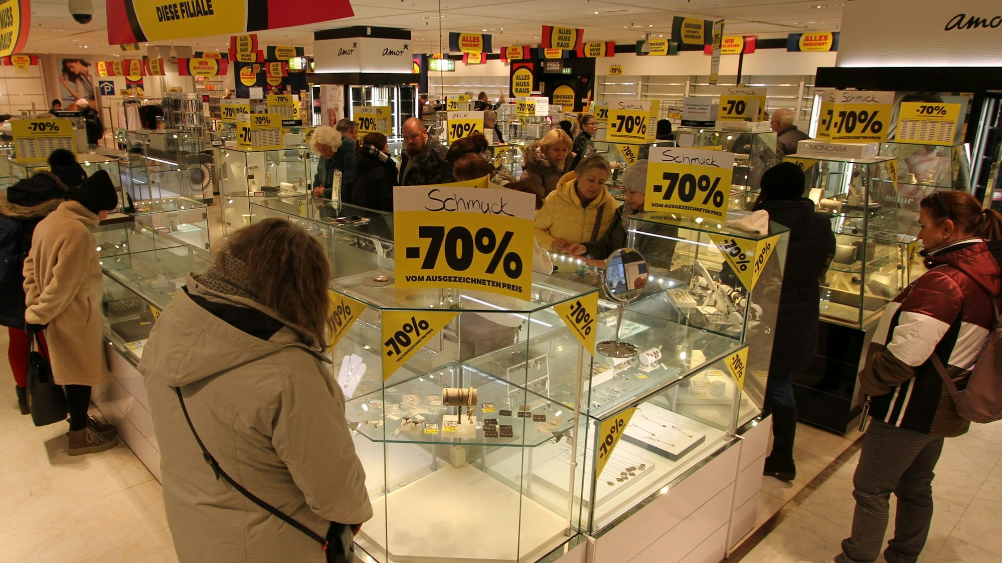 Kunden vor fast leeren Verkaufsvitrinen in einem Warenhaus