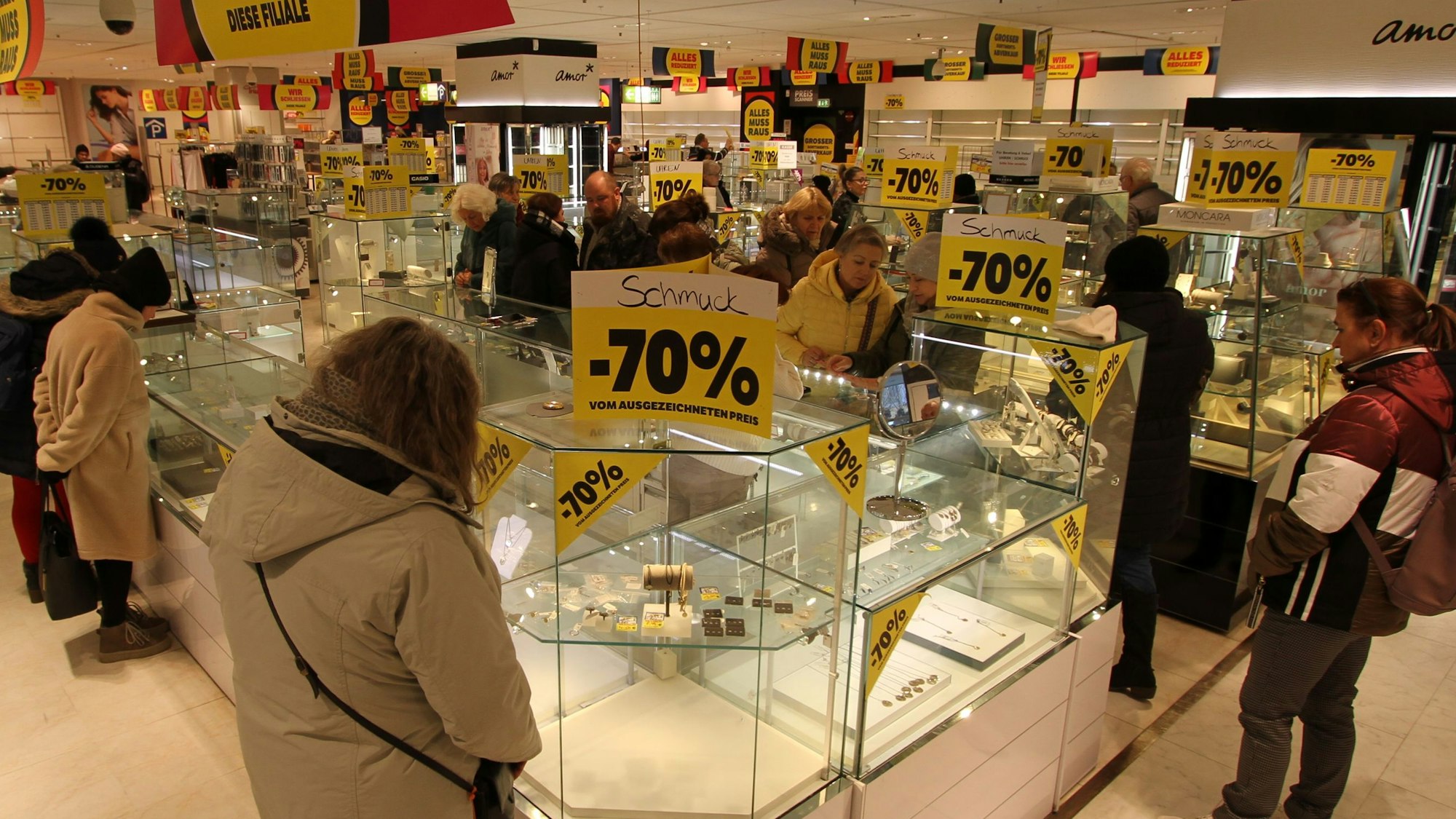 Kunden vor fast leeren Verkaufsvitrinen in einem Warenhaus