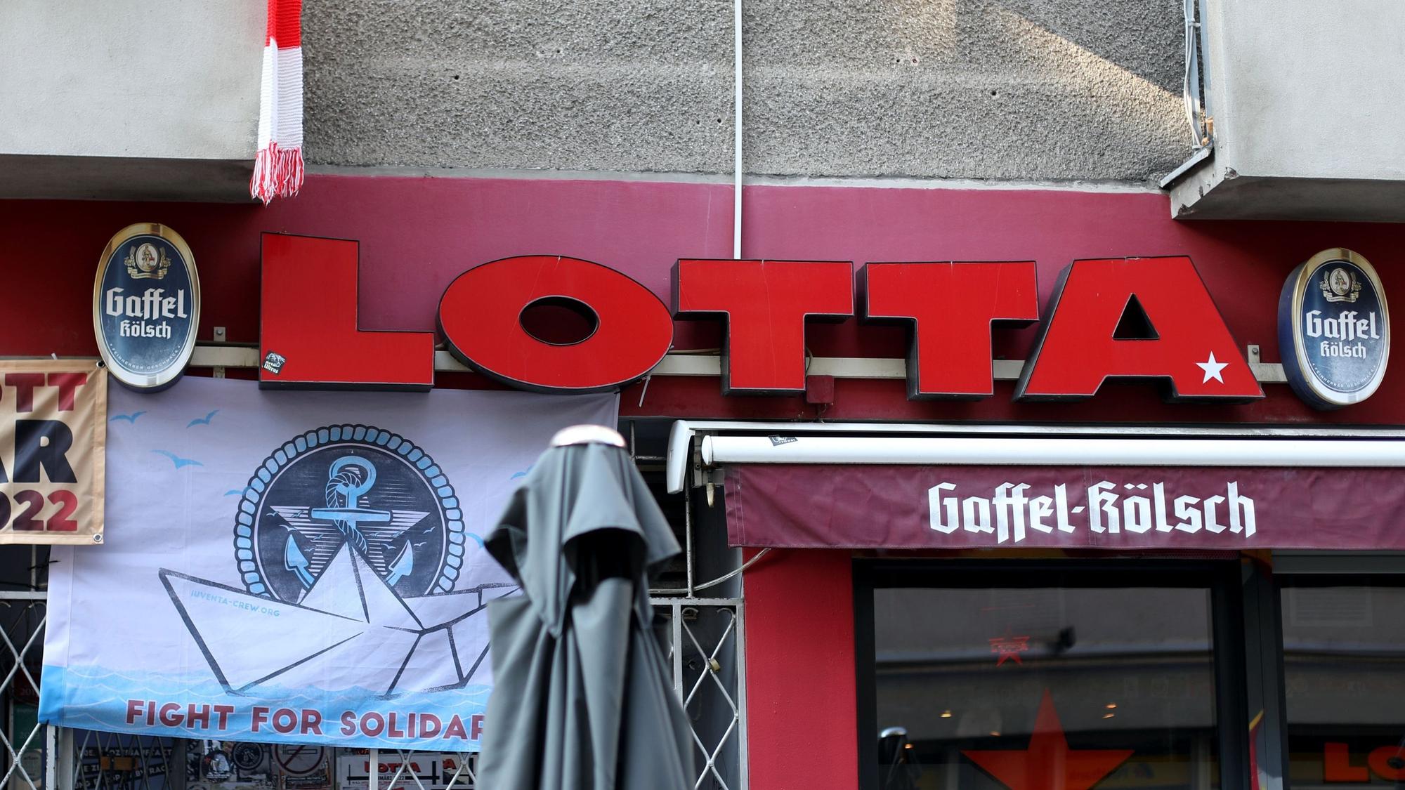 Zu sehen ist die Front der Kneipe Lotta mit Schriftzug und verschiedenen Plakaten.