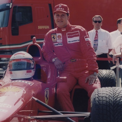 Michael Schumacher lehnt sich an einen Ferrari.