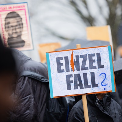 Demonstranten stehen mit Plakaten, die das Portrait des 16-jährigen Senegalesen Mouhamed Drame zeigen, vor dem Landgericht. Hier beginnt der Prozess nach tödlichen Polizeischüssen auf den jungen Flüchtling.