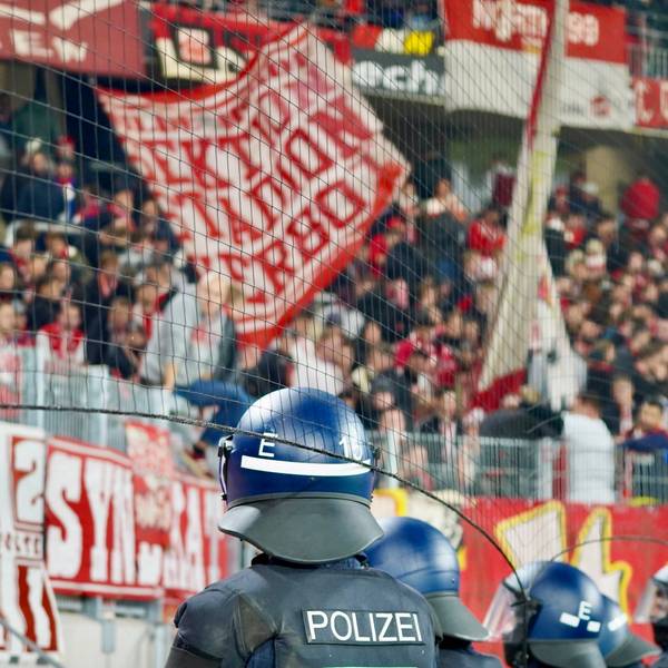 Polizisten blicken beim Auswärtsspiel des 1. FC Köln in Freiburg auf den Kölner Fan-Block. (Archivbild)