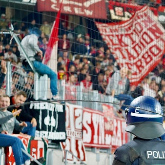 Polizisten blicken beim Auswärtsspiel des 1. FC Köln in Freiburg auf den Kölner Fan-Block. (Archivbild)
