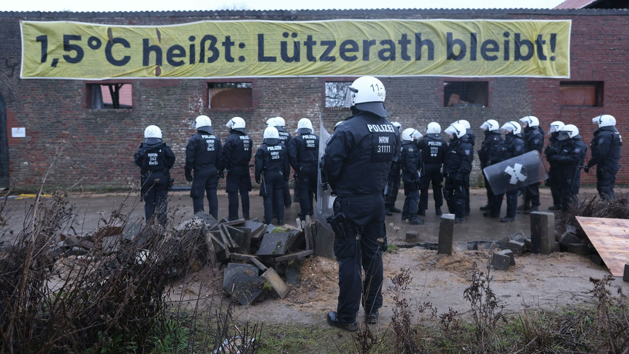 Polizisten stehen am zweiten Tag der Räumung im von Klimaaktivisten besetzten Braunkohleort Lützerath. Der Energiekonzern RWE will die unter Lützerath liegende Kohle abbaggern - dafür soll der Weiler auf dem Gebiet der Stadt Erkelenz am Braunkohletagebau Garzweiler II abgerissen werden. +++ dpa-Bildfunk +++