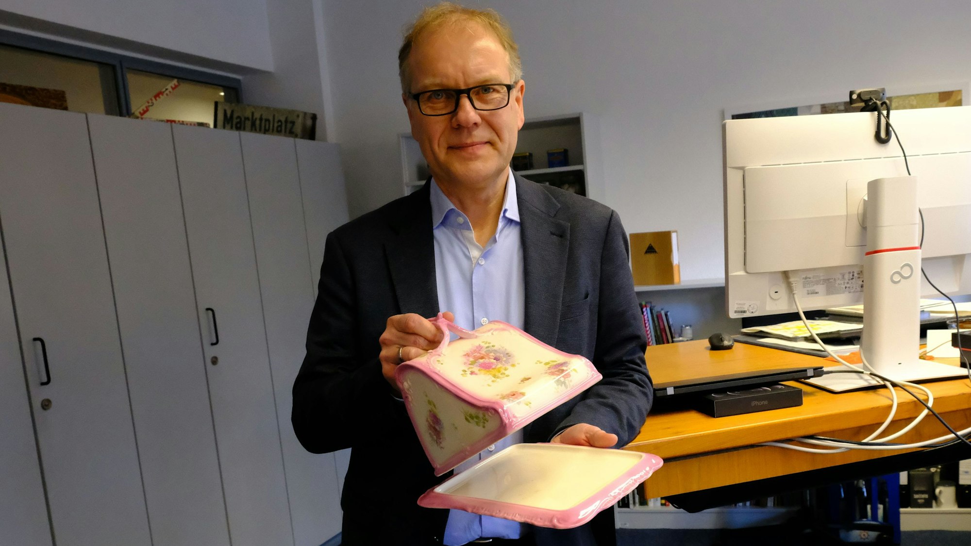 Dr. Carsten Vorwig präsentiert in seinem Büro eine „kitschige“ Butterdose.