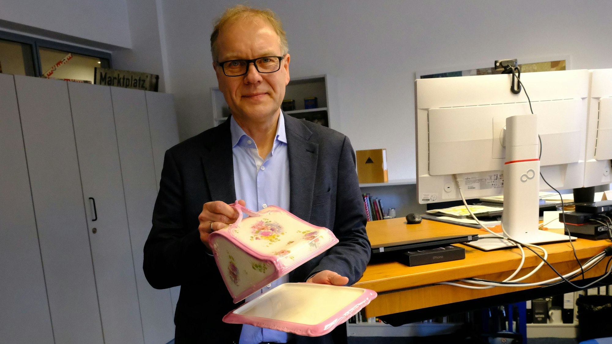 Dr. Carsten Vorwig, Direktor des LVR-Freilichtmuseums Kommern, präsentiert eine „kitschige“ Käseglocke aus Porzellan.