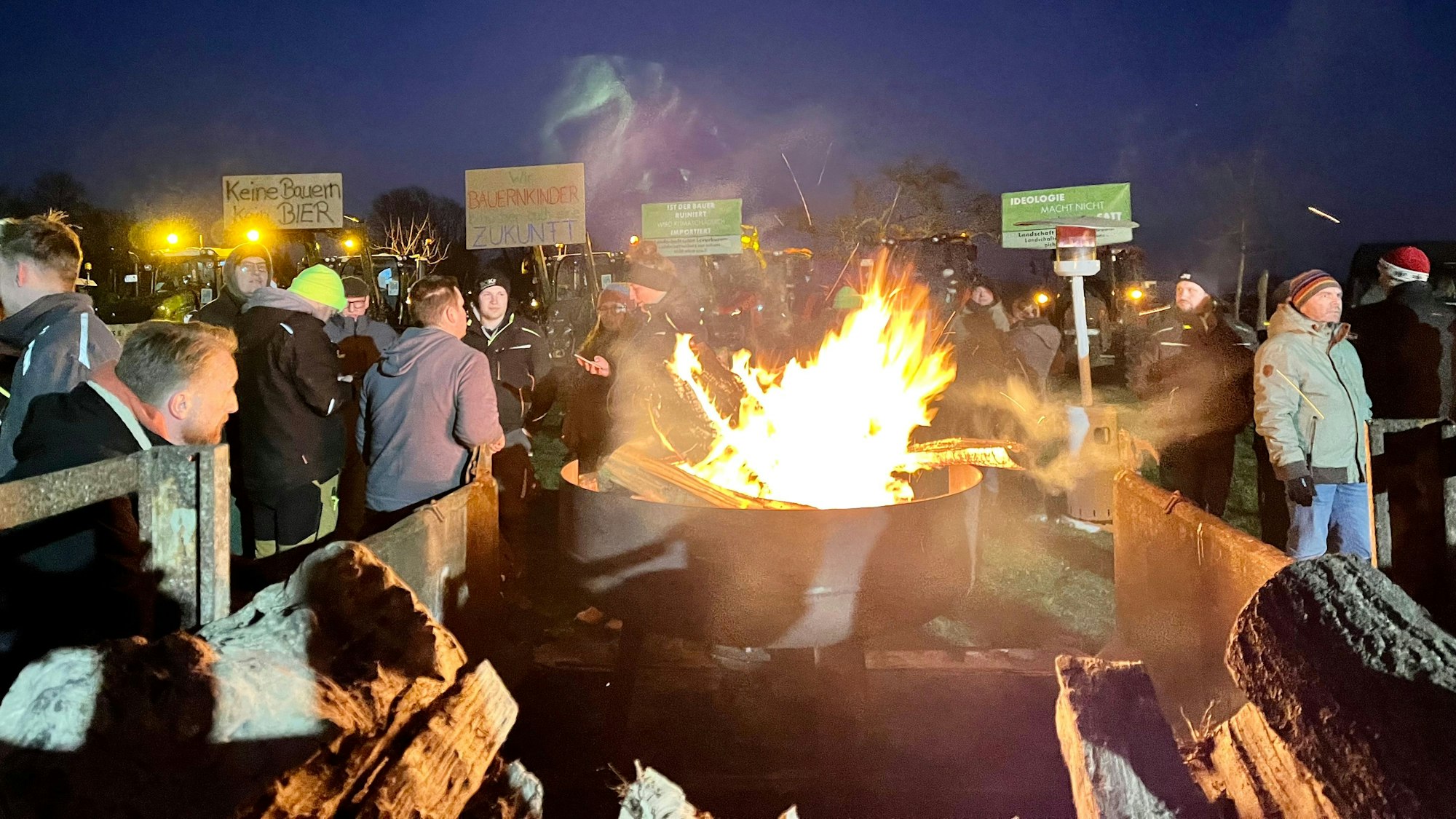 Bauern protestieren mit Mahnfeuer und Schildern.