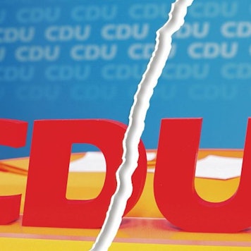 Ein Riss geht durch ein Bild vom Schriftzug CDU bei einem Kreisparteitag der CDU Rhein-Berg.