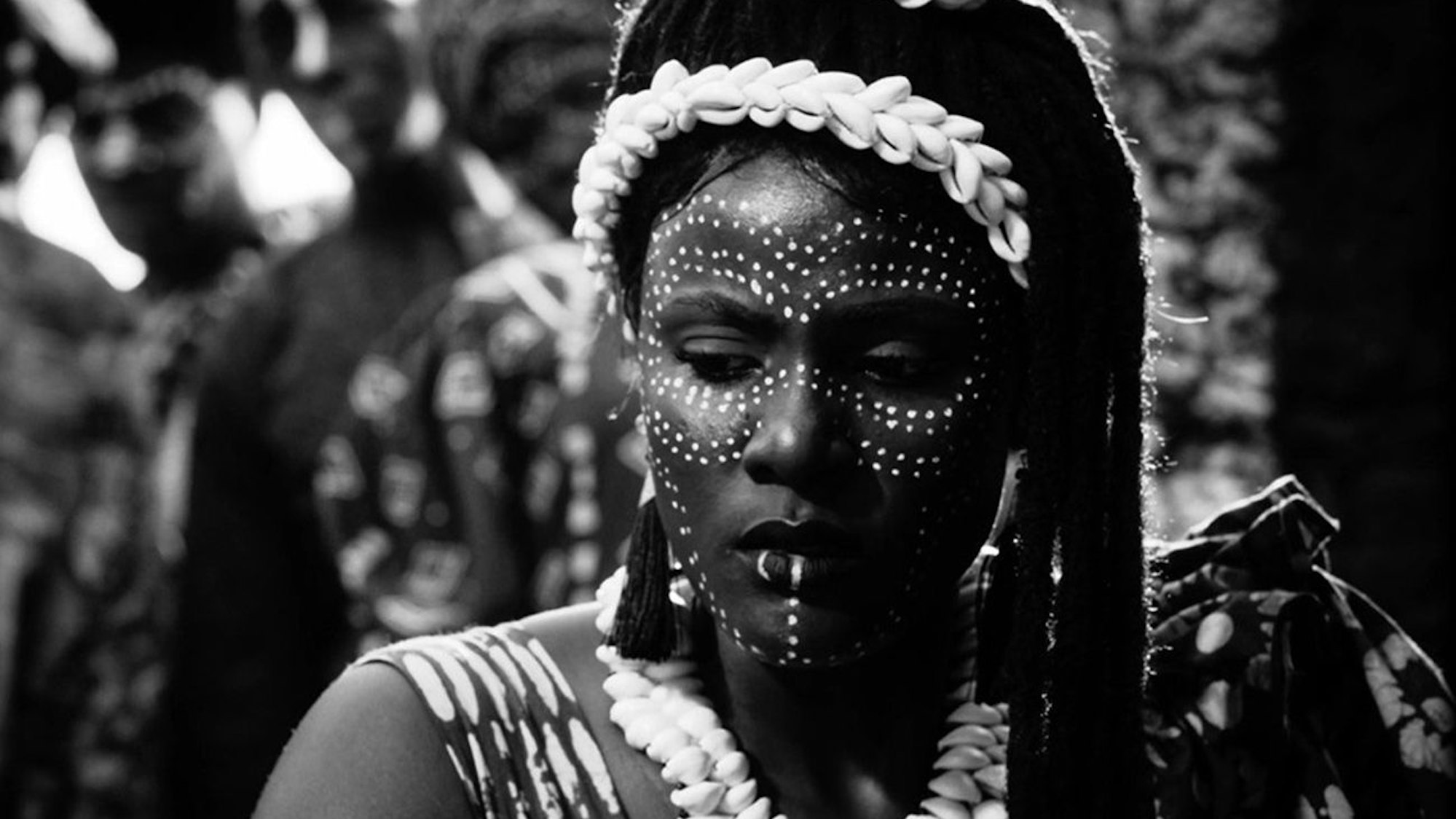 Eine Frau mit Gesichtsschmuck schaut in die Kamera.