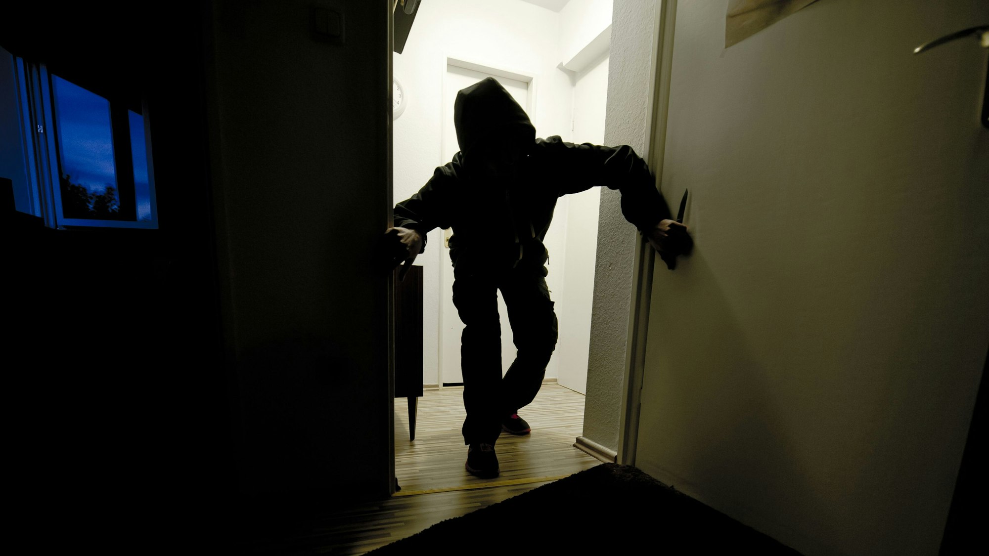 Ein bewaffneter Mann schleicht durch eine Wohnung.