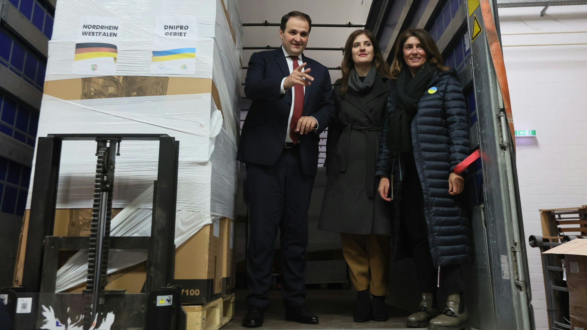 Winterhilfspaket für Ukraine, Minister Nathanael Liminski (Minister für Bundes- und Europaangelegenheiten, Internationales sowie Medien des Landes Nordrhein-Westfalen und Chef der Staatskanzlei)
begleitet Auslieferung in Köln, links: Iryna Shum (Generalkonsulin Ukraine), rechts: Linda Mai (Vorsitzende Verein blau-gelbes Kreuz), 20.12.2023, Bild: Herbert Bucco