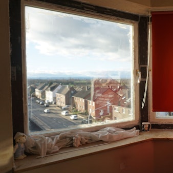 Josef Schwingeler steht vor seinem Fenster mit Blick auf eine Weilerswister Straße.