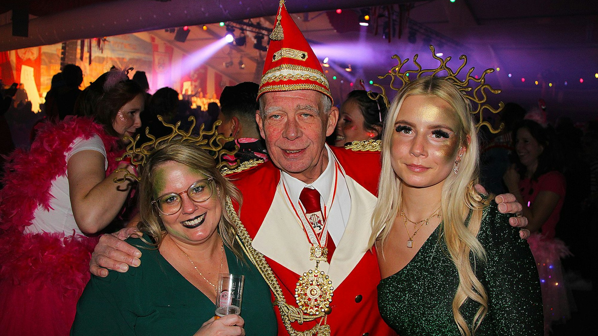 KG-Präsident Udo Kreitz hält die als Medusen verkleideten Frauen Sabina und Laura im Arm.