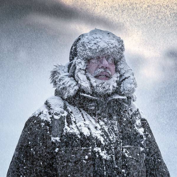 Verschneiter Mann im Winteroutfit.